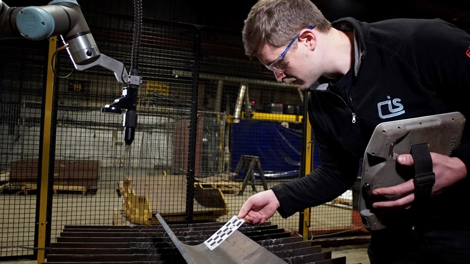 Mason Fraser programs the UR plasma-cutting application, using a checker board to calibrate the vision system.  
